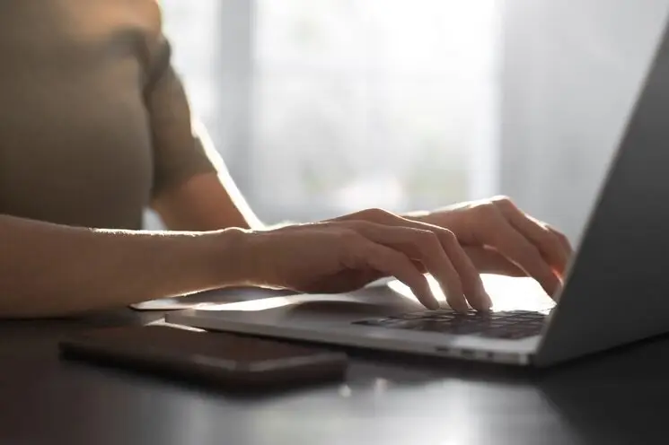 hands typing on a computer